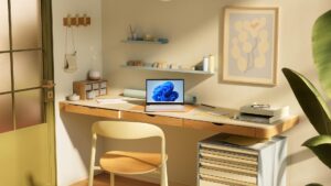 Entorno de trabajo en el hogar con una decoración nórdica. En el centro, un portátil con el escritorio de Windows 11 en la pantalla sobre una mesa de madera