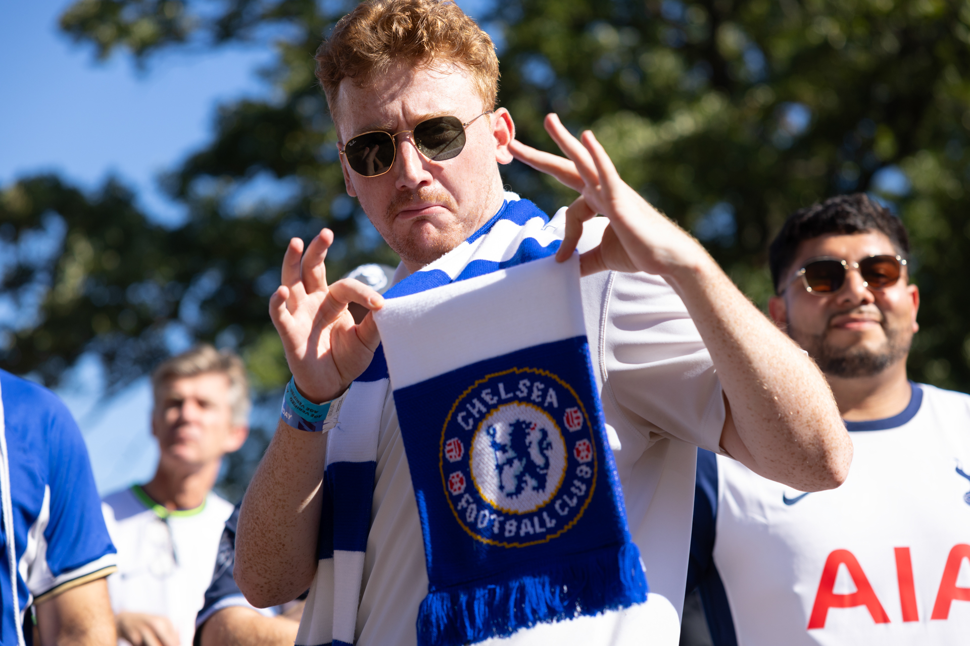 A Chelsea fan holds up his scarf to show off the team’s crest.